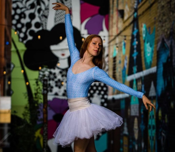 Daniela Maaraoui poses in Black Cat Ally, while wearing a blue leotard, white tutu, and pointe shoes