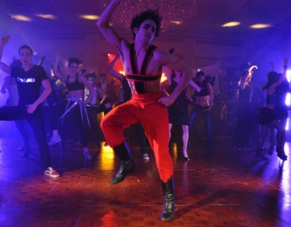 Barry Molina jumping in the air while wearing a red, rock and roll, costume