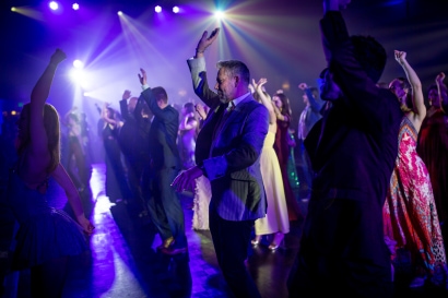guests take on the dance floor with stage lights behind them