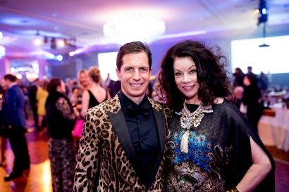 two guests smile for a picture, in animal print formal attire