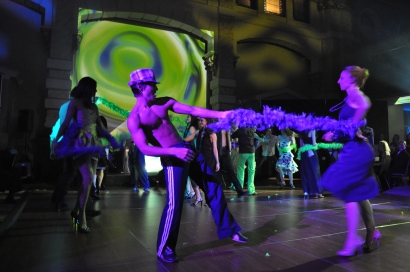 two dancers performing while playing with a feather boa