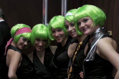a group of dancers smiling with neon green wigs on
