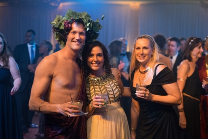 three guests smile and pose for a picture in their greek inspired attire