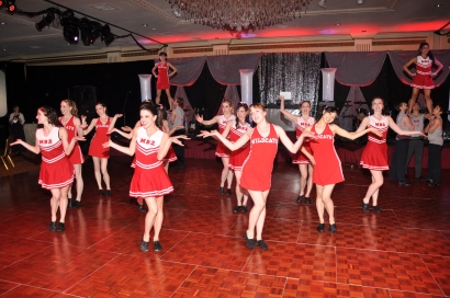 dancers perform at the ball, while wearing red cheerleading outfits