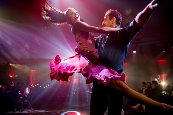 a male dancer holding a female dancer on his hip, while spinning in a circle