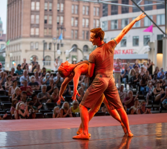 two people dancing on stage with a crowd watching