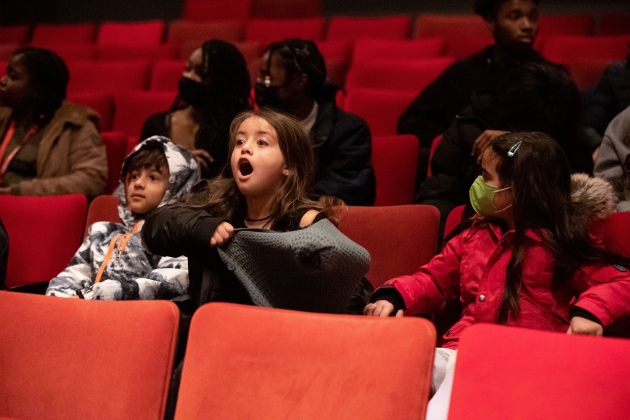 three kids sit amazed at the student matinee of The Nutcracker